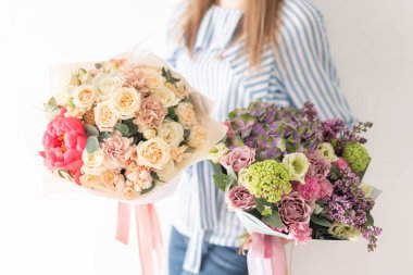 Kadın elinde karışık çiçek iki güzel buketleri. bir çiçekçi de çiçekçi çalışmaları. Narin Pastel rengi. Taze kesilmiş çiçek.