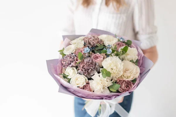 Beautiful bouquet of mixed flowers in woman hand. the work of the florist at a flower shop. Delicate Pastel color. Fresh cut flower. White and lilac color — Stock Photo, Image