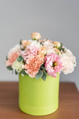 yuvarlak kutuda karışık çiçek güzel taze buket . Çiçekçi dükkanındaki çiçekçinin işi. Çiçek teslimi