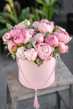 Eski gri masadaki pembe şakayıklar. Katalog veya online mağaza için güzel şakayık çiçek. Çiçek dükkanı konsepti . Güzel taze kesme buketi. Çiçek teslimatı