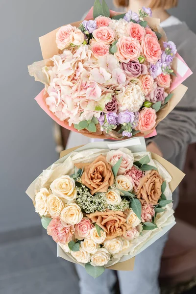 Dois pequenos e bonitos buquês de flores mistas na mão da mulher. Conceito de loja floral. Belo buquê de corte fresco. Entrega de flores — Fotografia de Stock