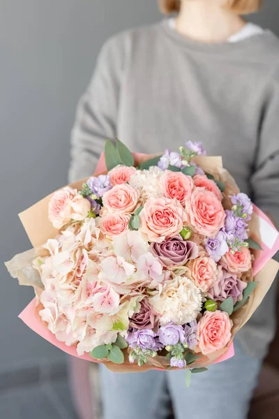 Kis gyönyörű csokor vegyes virágok a nő kezét. Floral Shop koncepció. Gyönyörű friss vágott csokor. Virágok szállítása — Stock Fotó