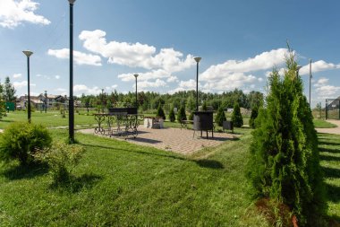 Halka açık bir piknikte ızgara. Barbekü tezgâhı, kamp alanında ızgara. Dinlenme için banklar ve Park'taki Oyun Alanı