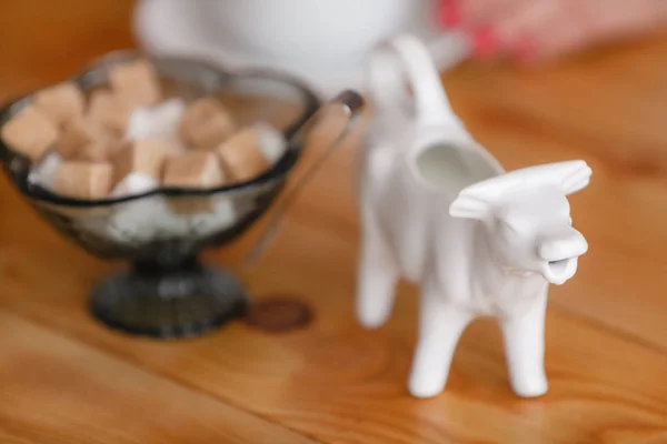 Coffee cup on wooden table in restaurant. Light morning Breakfast. Gravy boat with milk in the form of cow — Stock Photo, Image