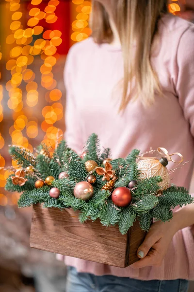 Belo arranjo festivo de abeto fresco com brinquedos de bola em uma caixa de madeira rústica. Humor de Natal. Bokeh de luzes de guirlanda no fundo. — Fotografia de Stock