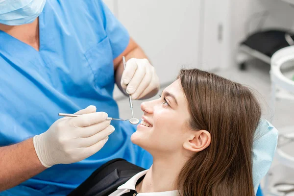 Joven mujer hermosa en la silla del dentista en la clínica dental. Medicina, salud, concepto estomatológico. dentista tratando a un paciente. Mujer sonriendo — Foto de Stock
