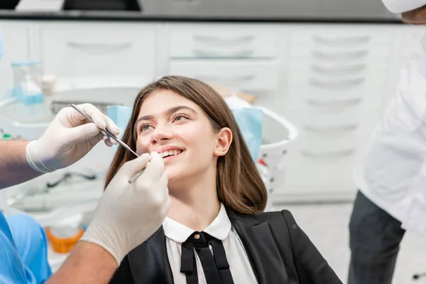 Mladá krásná žena na zubařské židli na zubní klinice. Koncepce medicíny, zdraví, stomatologie. zubař ošetřující pacienta. Usměvavá žena — Stock fotografie