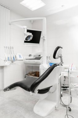 Dikey görünüm siyah koltuk ile bir diş hekimi odası. Modern diş uygulama. Diş sandalye ve diş hekimleri tarafından kullanılan diğer aksesuarları