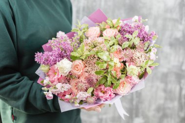 Çiçekçi bir buket tutuyor. Güzel bahar çiçekleri. Karışımı çiçekler ile düzenleme. Bir çiçek dükkanı kavramı, küçük bir aile iş. İş çiçekçi. Kopyalama alanı