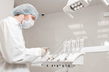 Bir doktorun işi. Diş kliniğinde genç adam dişçi. Tıp, sağlık, Stomatoloji konsepti. hasta tedavi dişçi.