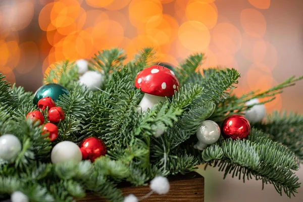 精美的节日布置，新鲜云杉与球玩具在一个乡村木箱。圣诞气氛。背景上加兰灯的Bokeh. — 图库照片