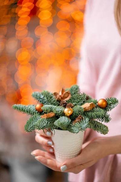 Belo arranjo festivo de abeto fresco com brinquedos de bola na xícara de café. Humor de Natal. Bokeh de luzes de guirlanda no fundo . — Fotografia de Stock