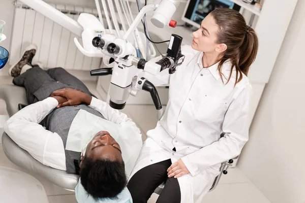 Dentista mulher usuário avançado, ferramentas dentárias. Microscópio de configuração para examinar os dentes dos pacientes. no consultório odontológico. Conceito de medicina, odontologia e cuidados de saúde . — Fotografia de Stock