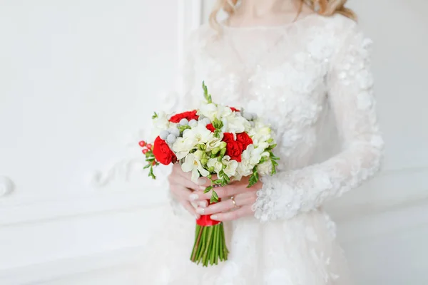 Braut hält Brautstrauß aus nächster Nähe. rote und weiße Rosen, Freesia, Brunia dekoriert. — Stockfoto