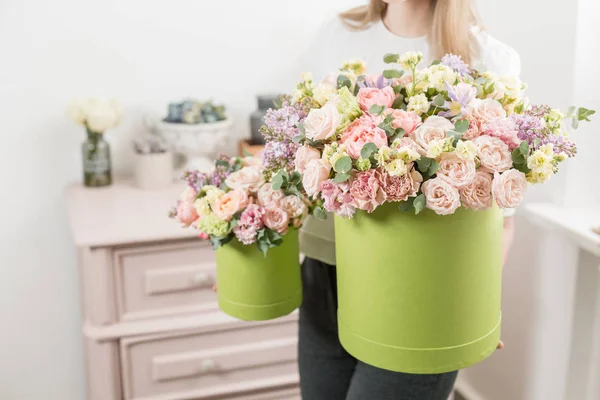 Two Beautiful spring bouquets in head box. Arrangement with mix flowers. The concept of a flower shop, a small family business. Work florist. copy space