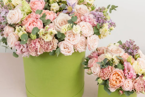 Two Beautiful spring bouquets in head box. Arrangement with mix flowers. The concept of a flower shop, a small family business. Work florist. copy space