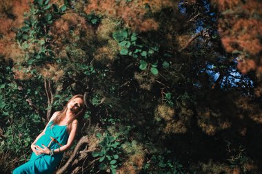 Parkta açık havada genç hamile kadın. Üçüncü trimesterde sakin hamile kadın. Halka açık bahçede yürüyüş.