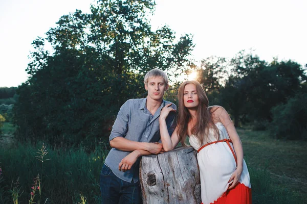 Genç güzel bir aile, müstakbel ebeveynler. Parkta hamile bir kadın. Üçüncü trimesterde sakin hamile kadın. Halka açık bahçede yürüyüş.