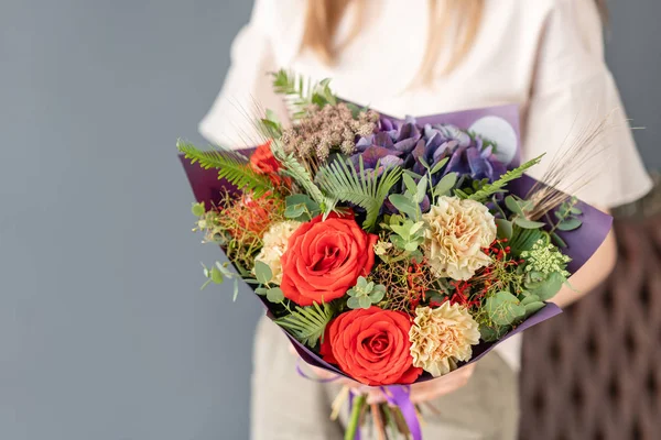 Small Beautiful bouquet of mixed flowers in woman hand. Floral shop concept . Beautiful fresh cut bouquet. Flowers delivery — Stock Photo, Image