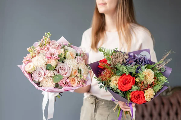 Dos pequeños ramos hermosos de flores mixtas en mano de mujer. Concepto de tienda floral. Hermoso ramo de corte fresco. Entrega de flores — Foto de Stock