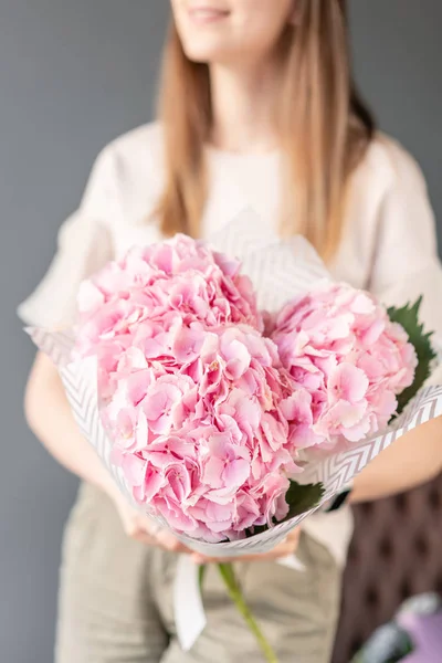 Pequeño hermoso ramo de flores de hortensia en mano de mujer. Concepto de tienda floral. Hermoso ramo de corte fresco. Entrega de flores — Foto de Stock