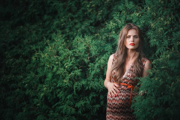 Jeune femme enceinte dans le parc à l'extérieur. Calme femme enceinte au troisième trimestre. Promenade dans le jardin public. Les arbres dans la forêt — Photo