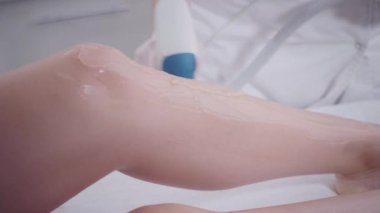 Yakın çekim Doktor kozmetolojist prosedürü genç bir kız esmer yapar. Lazer epilasyon ve kozmetoloji. Bayan ların bacaklarında epilasyon. kozmetik güzellik spa kliniğinde.