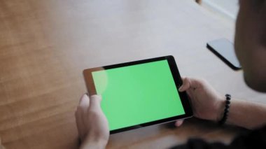 Genç adam tablet bilgisayarında yazıyor, sohbet ediyor, blog yazıyor. Modern çalışma ağları üzerinde serbest çalışan bir yazar. Uzaktan kumandalı programcı. Başarılı insanlar, rahat bir kafede iş adamı. Yüksek Büyük Pencereler