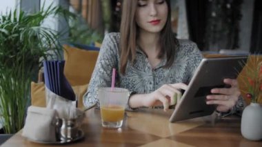 Tablet bilgisayarında yazan, sohbet eden, blog yazan genç bir kadın. Kafe Modern İş Arkadaşlığı 'nda serbest çalışan biri. Başarılı insanlar, rahat bir kafede iş adamı. Yüksek Büyük Pencereler