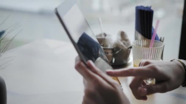 Jovem digitando no computador tablet, conversando, blogando. Trabalho freelancer no café coworking moderno. Pessoas de sucesso, homem de negócios em café confortável. Janelas grandes altas — Vídeo de Stock