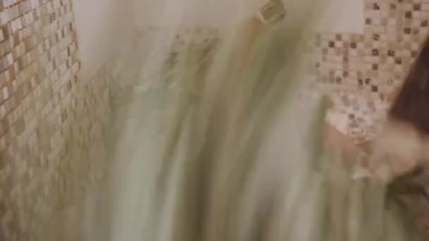 Mujer delgada en el baño está recibiendo masaje al vapor con escobas de hojas de roble caliente, en el baño de vapor — Vídeo de stock