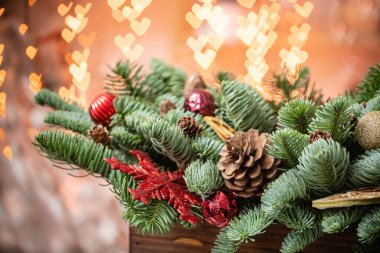 Noel havası. Rustik ahşap bir kutu içinde taze ladin güzel şenlikli düzenleme. Arka planda Garland ışıkları Bokeh kalpleri. Dilimler portakal, altın topları, koniler ile dekore