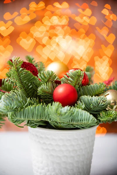 Weihnachtsstimmung. schönes festliches Arrangement aus frischen Fichten in einer rustikalen Holzkiste. Bokeh Herzen aus Girlanden Lichter auf dem Hintergrund. — Stockfoto