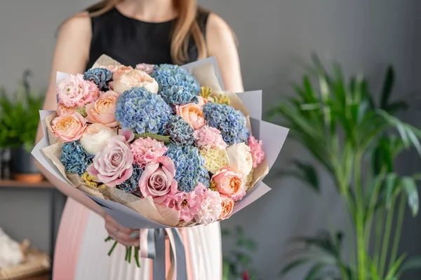 Kadın elinde karışık çiçek güzel buket. Çiçek dükkanı konsepti . Yakışıklı taze buket. Çiçek teslimatı. Mavi ve pembe renk — Stok fotoğraf