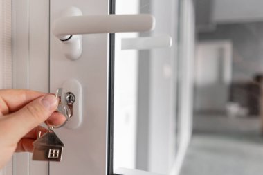 Erkekler el ev anahtarlık ile anahtar tutarak. Modern ışık lobisi iç mekan. Gayrimenkul, eve taşınmak ya da mülk kiralamak. Mortgage kavramı.