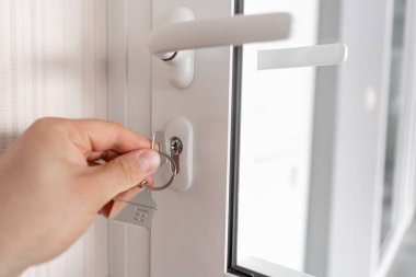 Modern ışık lobisi. Anahtarlığı olan adamlar el ele tutuşuyorlar. Gayrimenkul, eve taşınma ya da mülk kiralama. İpotek kavramı.