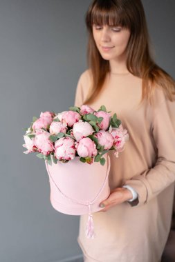 Pembe yuvarlak kutuda pembe şakayık. Katalog veya online mağaza için kadın elinde Güzel şakayık çiçek. Çiçek dükkanı konsepti. Çiçek teslimatı