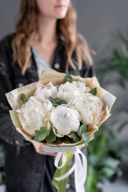 Kadın elinde beyaz şakayıklar. Katalog veya online mağaza için güzel taze şakayık çiçek. Çiçek dükkanı konsepti. Çiçek teslimatı