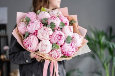 Kadın elinde pembe şakayık. Katalog veya online mağaza için güzel şakayık çiçek. Çiçek dükkanı konsepti . Güzel taze kesme buketi. Çiçek teslimatı