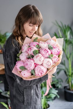 Kadın elinde pembe şakayık. Katalog veya online mağaza için güzel şakayık çiçek. Çiçek dükkanı konsepti . Güzel taze kesme buketi. Çiçek teslimatı