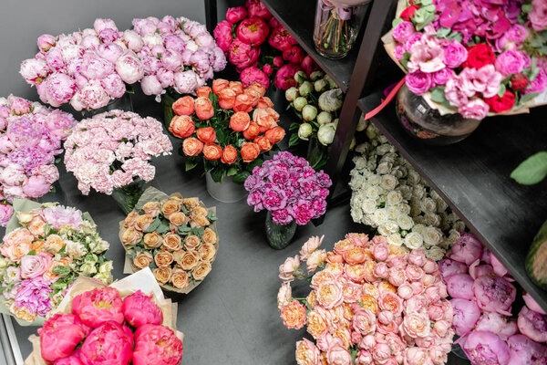 Вазы с разноцветными цветами, витрина цветочного магазина. Прекрасные весенние букеты. - Да. Маленький семейный бизнес. Рабочий флорист. копировальное пространство