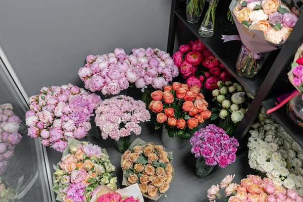 Вазы с разноцветными цветами, витрина цветочного магазина. Прекрасные весенние букеты. - Да. Маленький семейный бизнес. Рабочий флорист. копировальное пространство