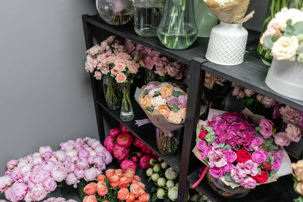 Вазы с разноцветными цветами, витрина цветочного магазина. Прекрасные весенние букеты. - Да. Маленький семейный бизнес. Рабочий флорист. копировальное пространство