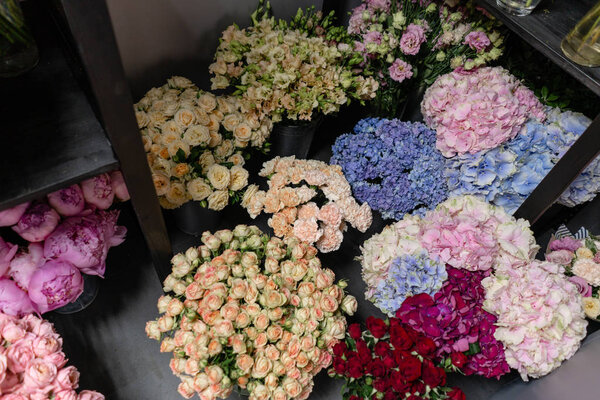 Вазы с разноцветными цветами, витрина цветочного магазина. Прекрасные весенние букеты. - Да. Маленький семейный бизнес. Рабочий флорист. копировальное пространство