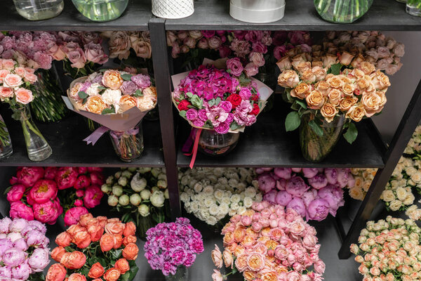 Вазы с разноцветными цветами, витрина цветочного магазина. Прекрасные весенние букеты. - Да. Маленький семейный бизнес. Рабочий флорист. копировальное пространство