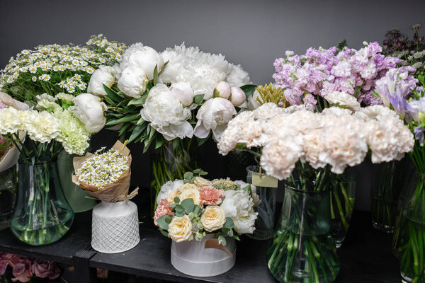 Вазы с разноцветными цветами, витрина цветочного магазина. Прекрасные весенние букеты. - Да. Маленький семейный бизнес. Рабочий флорист. копировальное пространство