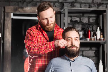 Berber sakal şekli yapıyor. Sakal kesme, yüz bakımı. Berber dükkanında çalışmak.