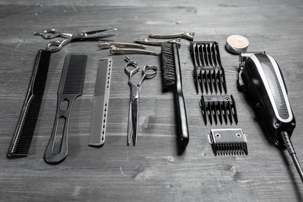Conjunto de herramientas profesionales de peluquería sobre fondo gris. Mesa de madera en barbería. Herramienta de trabajo del maestro peluquero — Foto de Stock
