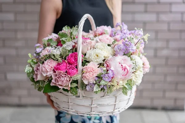 Arreglo floral en canasta de mimbre. Hermoso ramo de flores mixtas en mano de mujer. Concepto de tienda floral. Bonito ramo fresco. Entrega de flores — Foto de Stock