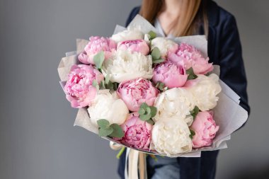 Pembe ve beyaz şakayıklar kadın ellerinde. Katalog veya online mağaza için güzel şakayık çiçek. Çiçek dükkanı konsepti . Güzel taze kesme buketi. Çiçek teslimatı